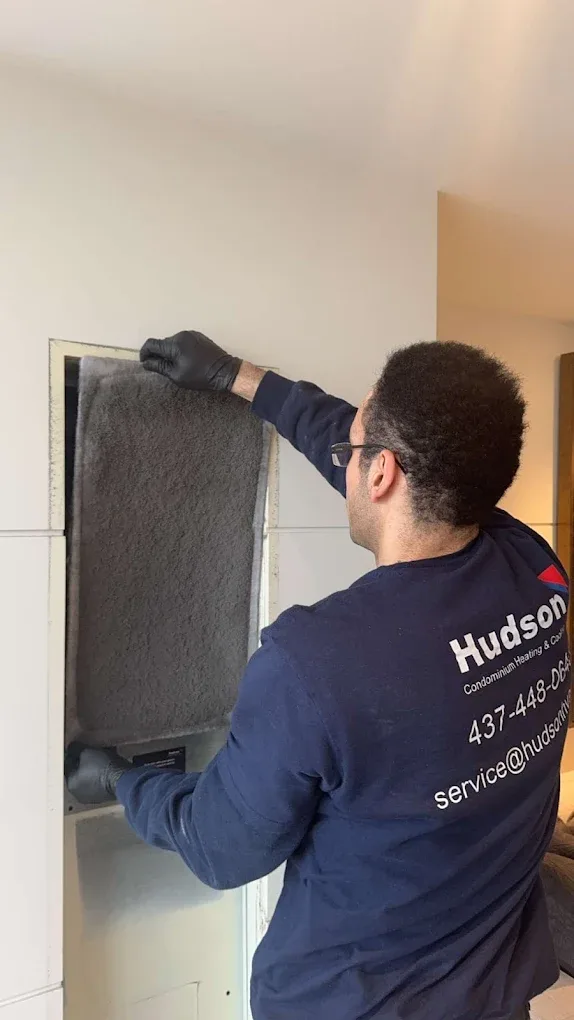Hudson technician changing fan coil filter