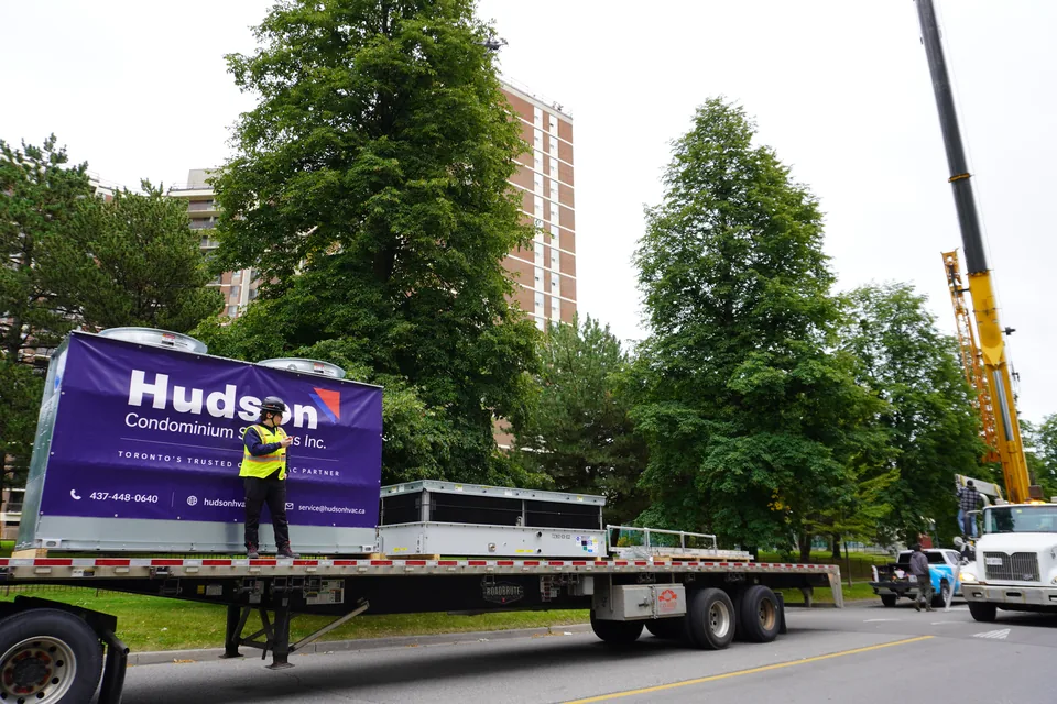 New cooling tower on a delivery truck beside the installation crane